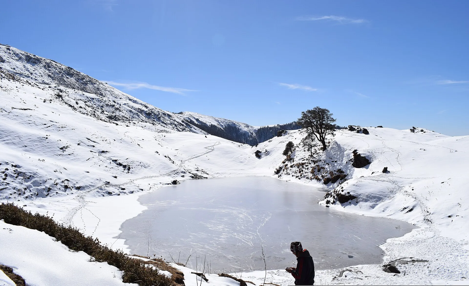 Brahmatal lake and snowy ridges on the Brahmatal trek, Chamoli, Uttarakhand