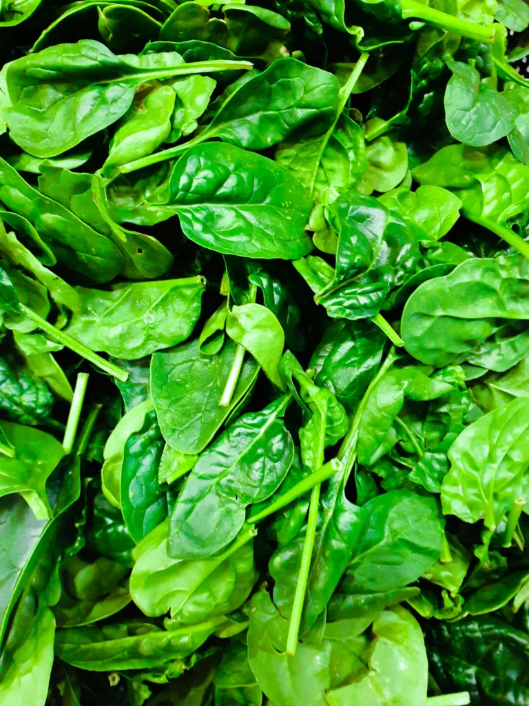 A pile of fresh spinach leaves, the main green in kafuli